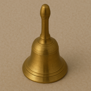 "Traditional brass puja bell (ghanti) with intricate handle design, placed on a red cloth background, used in Hindu religious rituals and ceremonies."