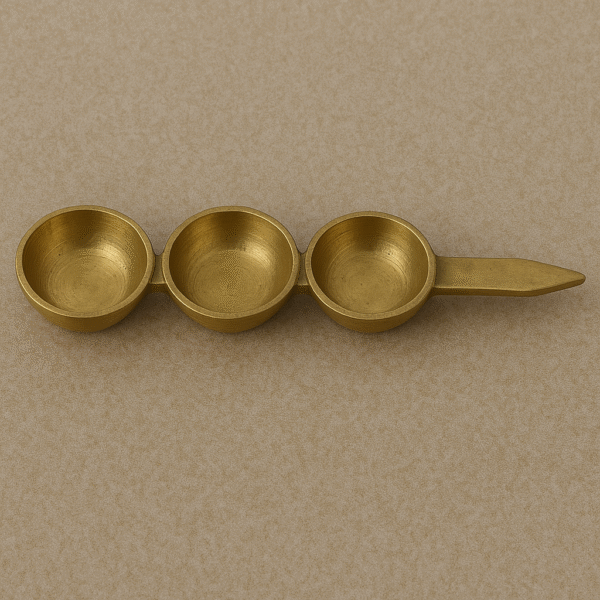 "Brass tilak stand with three compartments used for kumkum, haldi, and chawal in Hindu pooja rituals"
